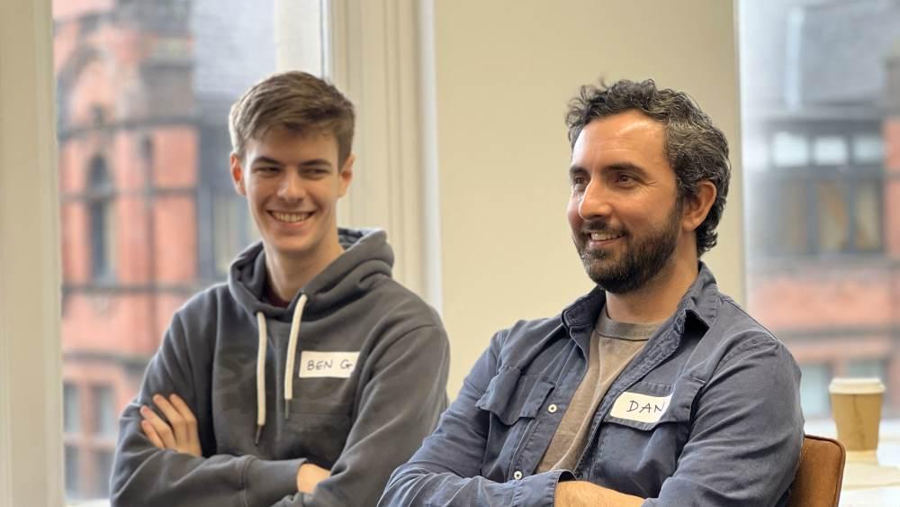 Two Spektrix engineers, wearing name badges, seated together at a team gathering