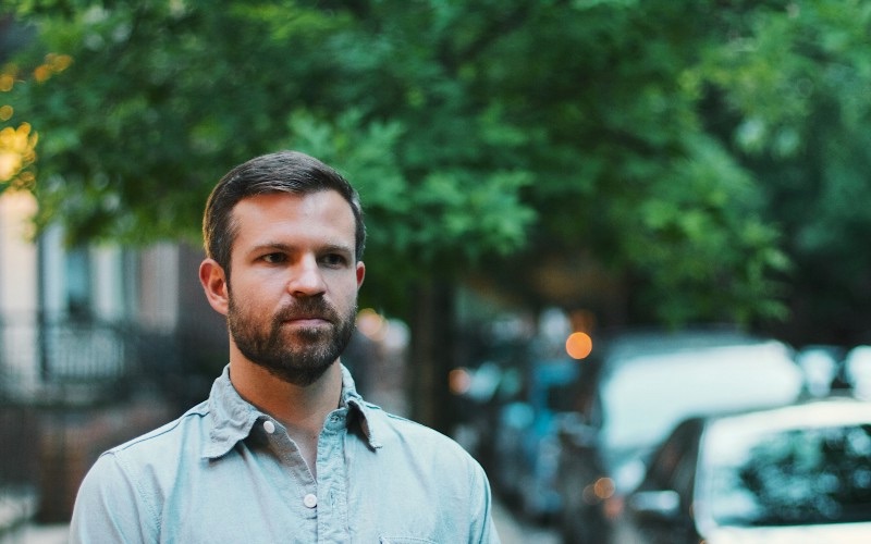 Spencer Fry standing outdoors on a tree-lined street