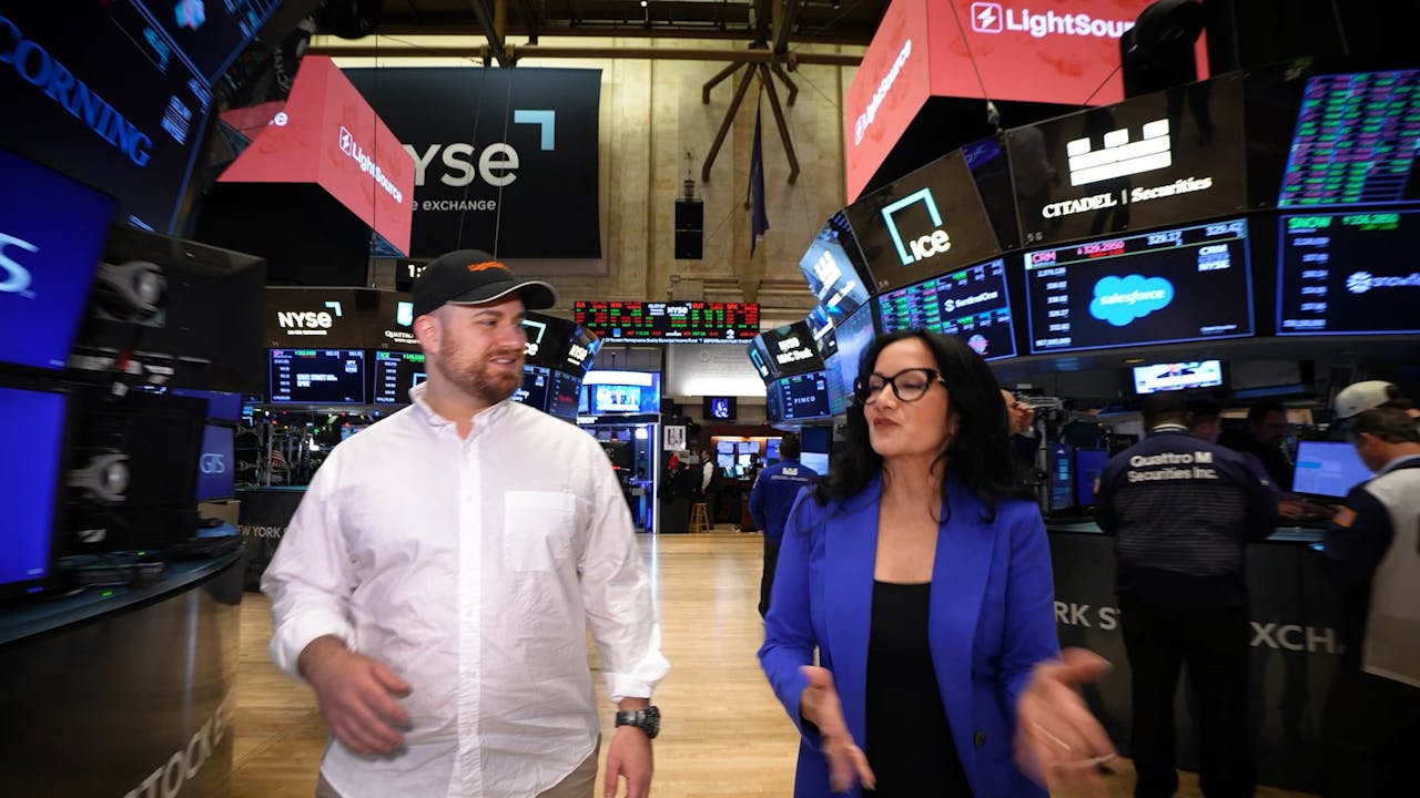 Spencer Penn and Judy Shaw walking through the New York Stock Exchange trading floor