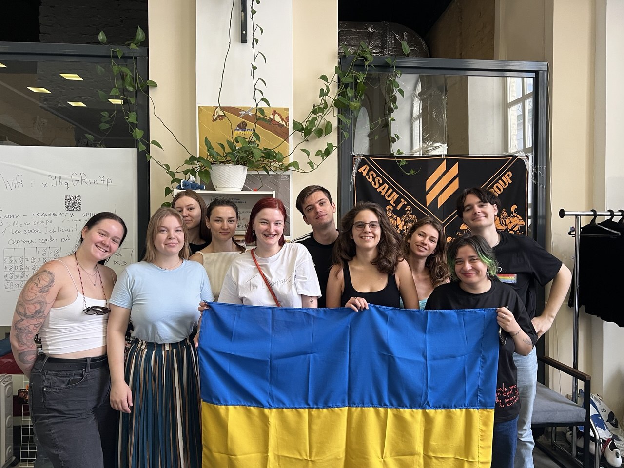 Spendbase team members gathered in an office holding a Ukrainian flag