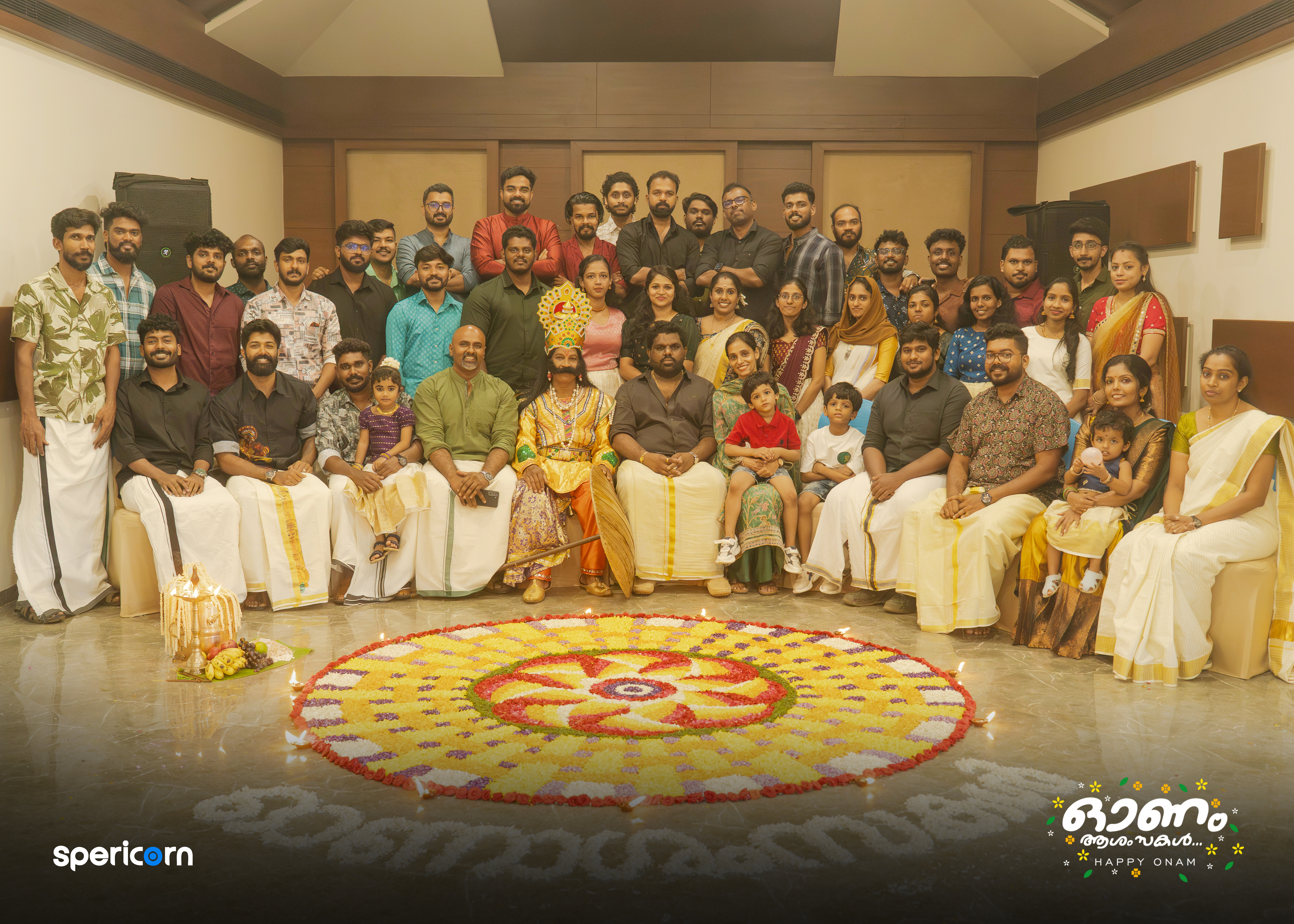 Spericorn team and families gathered around a floral arrangement for Onam 2025