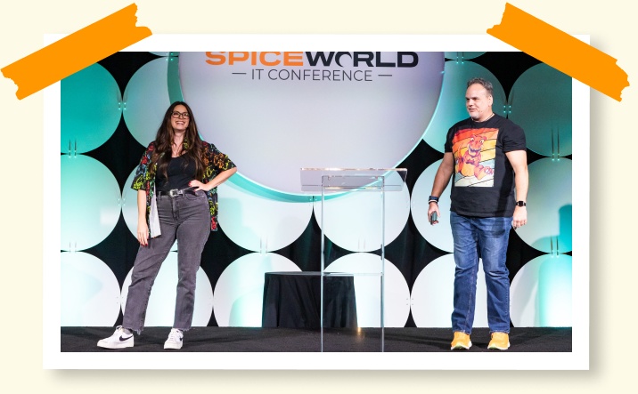 Two presenters on a SpiceWorld conference stage
