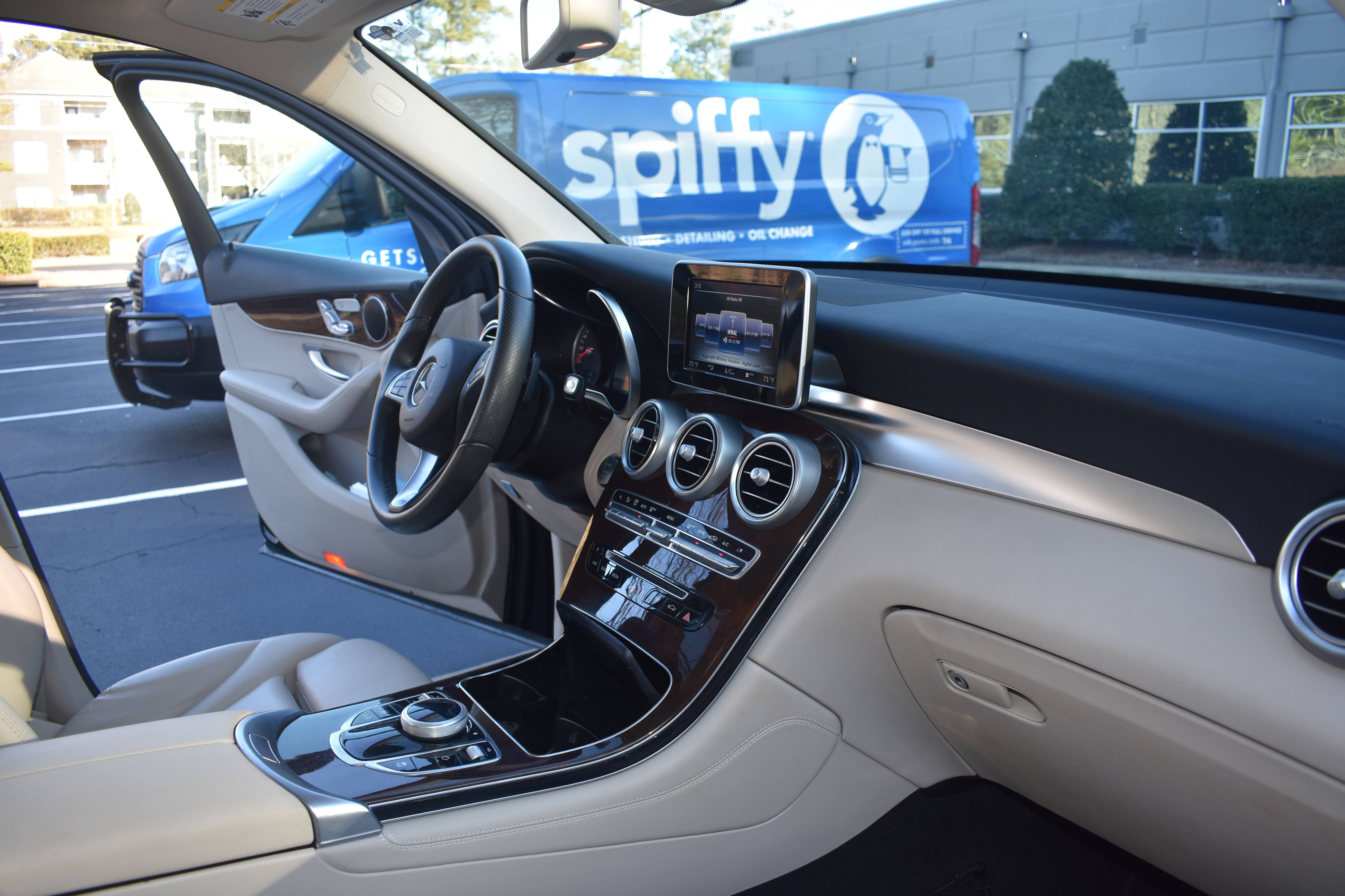 A clean vehicle interior with a blue Spiffy service van visible outside
