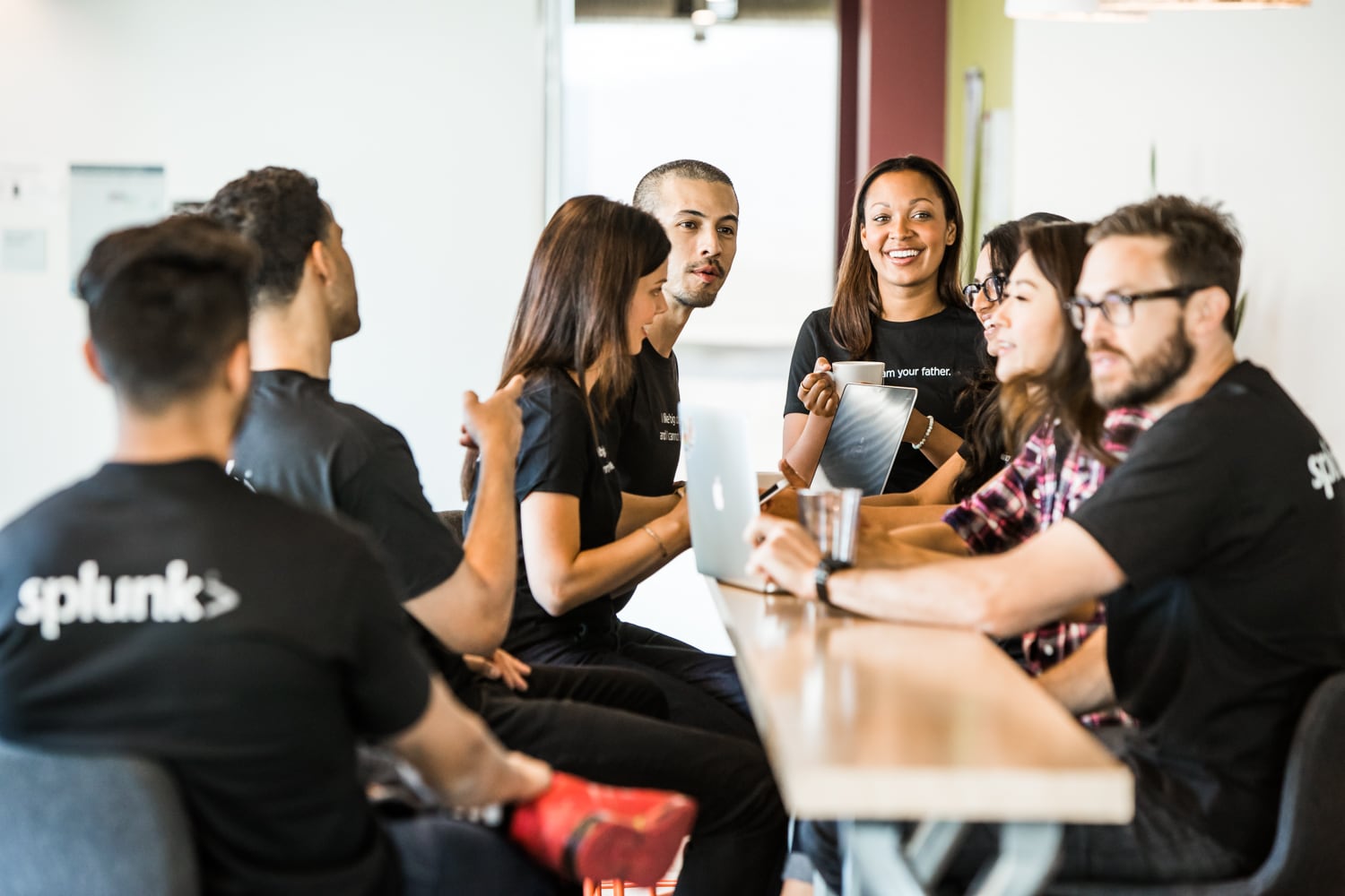 Splunk employees talking around a table in an office