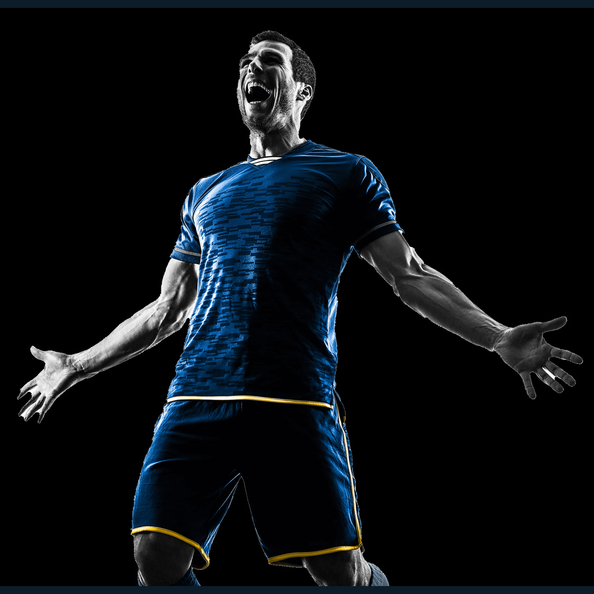 A footballer in a blue kit celebrates against a dark background