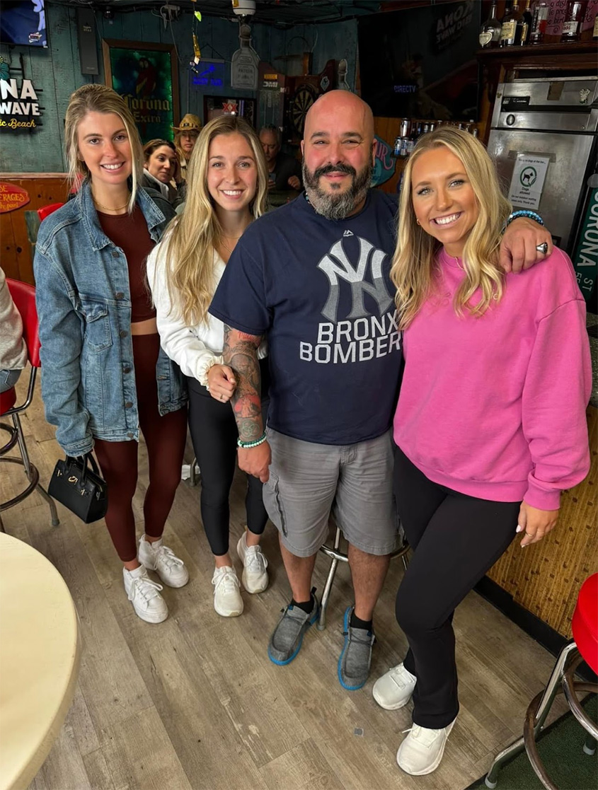 Four people pose together at a restaurant in a SpotHopper careers photograph