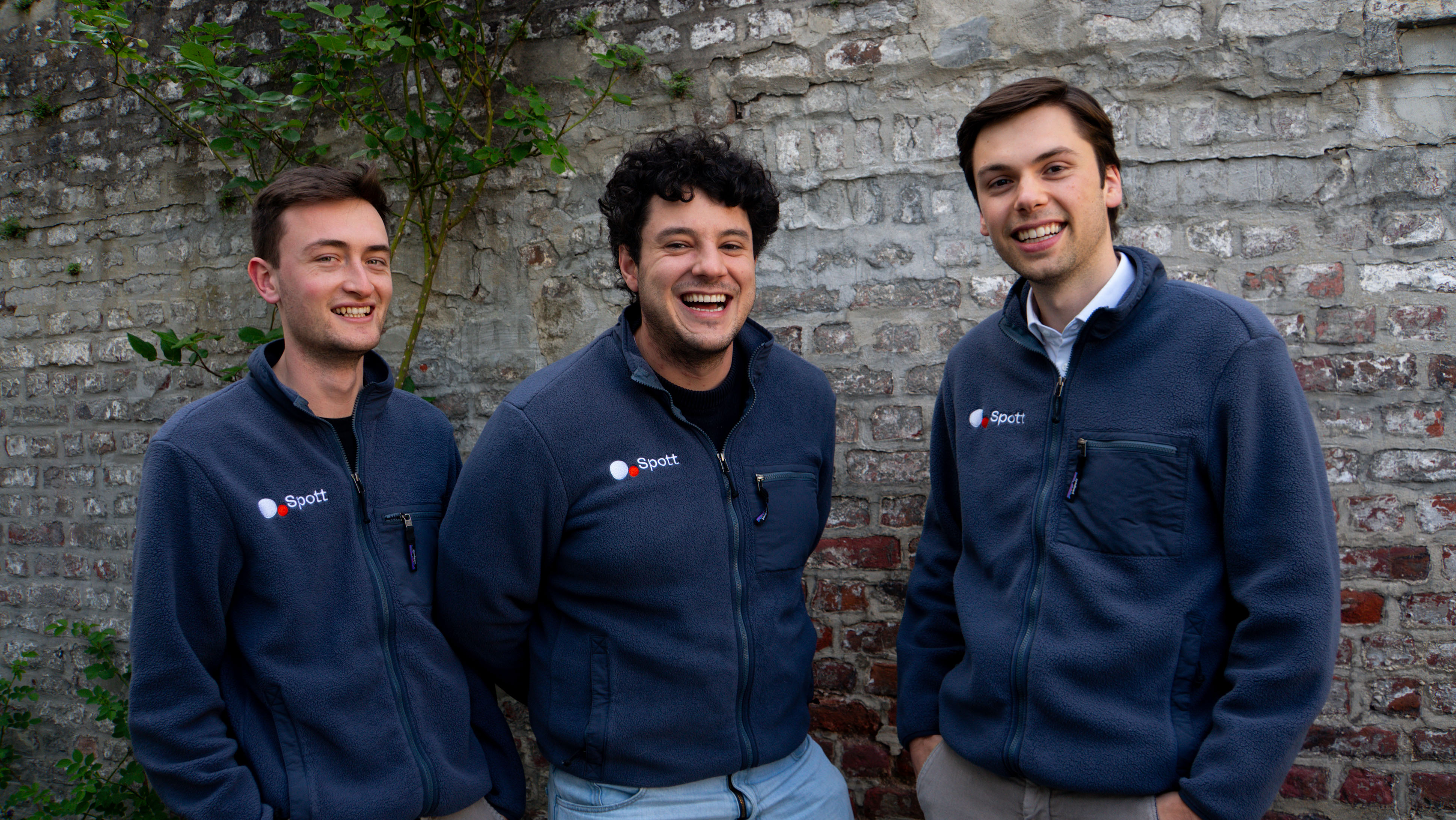 Spott co-founders Lander Degrève, Samuel Smeys and Manu Vanderveeren standing together in branded jackets