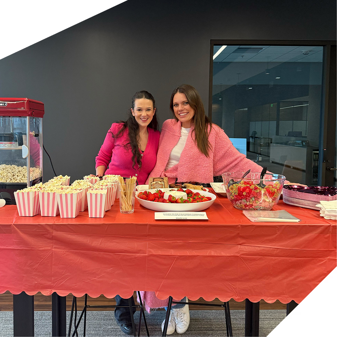 Two Spotter team members standing behind an office buffet