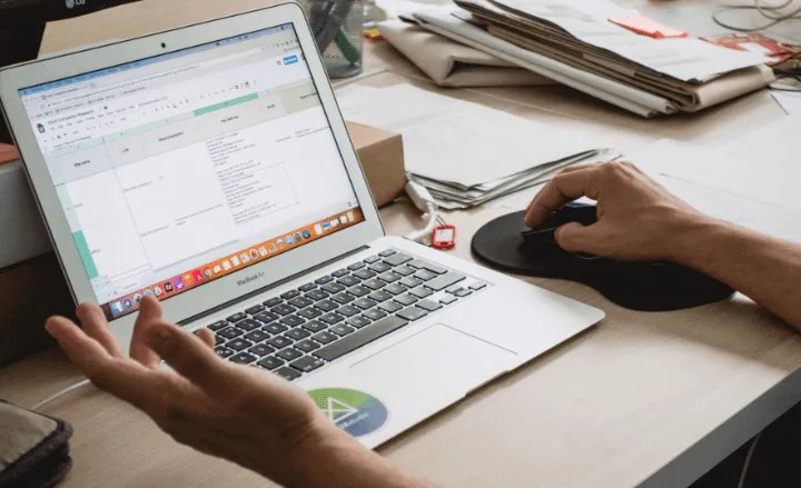 A person working with a spreadsheet-like interface on a laptop