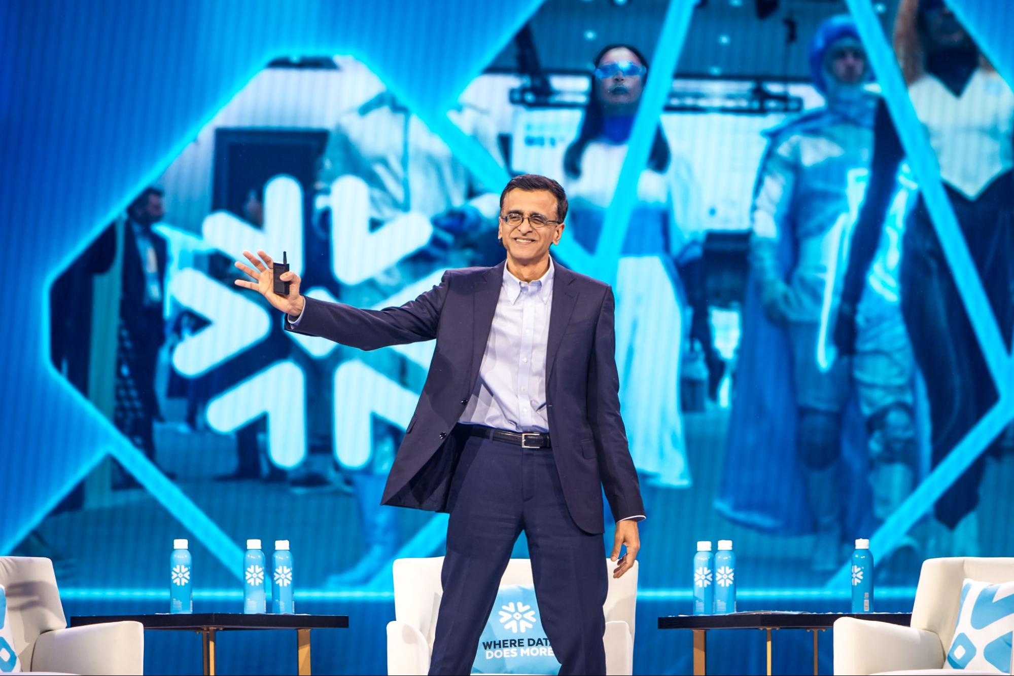 Sridhar Ramaswamy speaking on a blue-lit stage at Snowflake Summit 2025