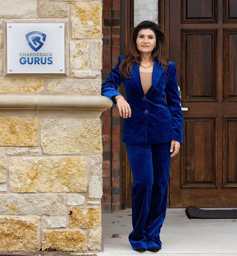 Srii Srinivasan in a blue suit beside the Chargeback Gurus office sign