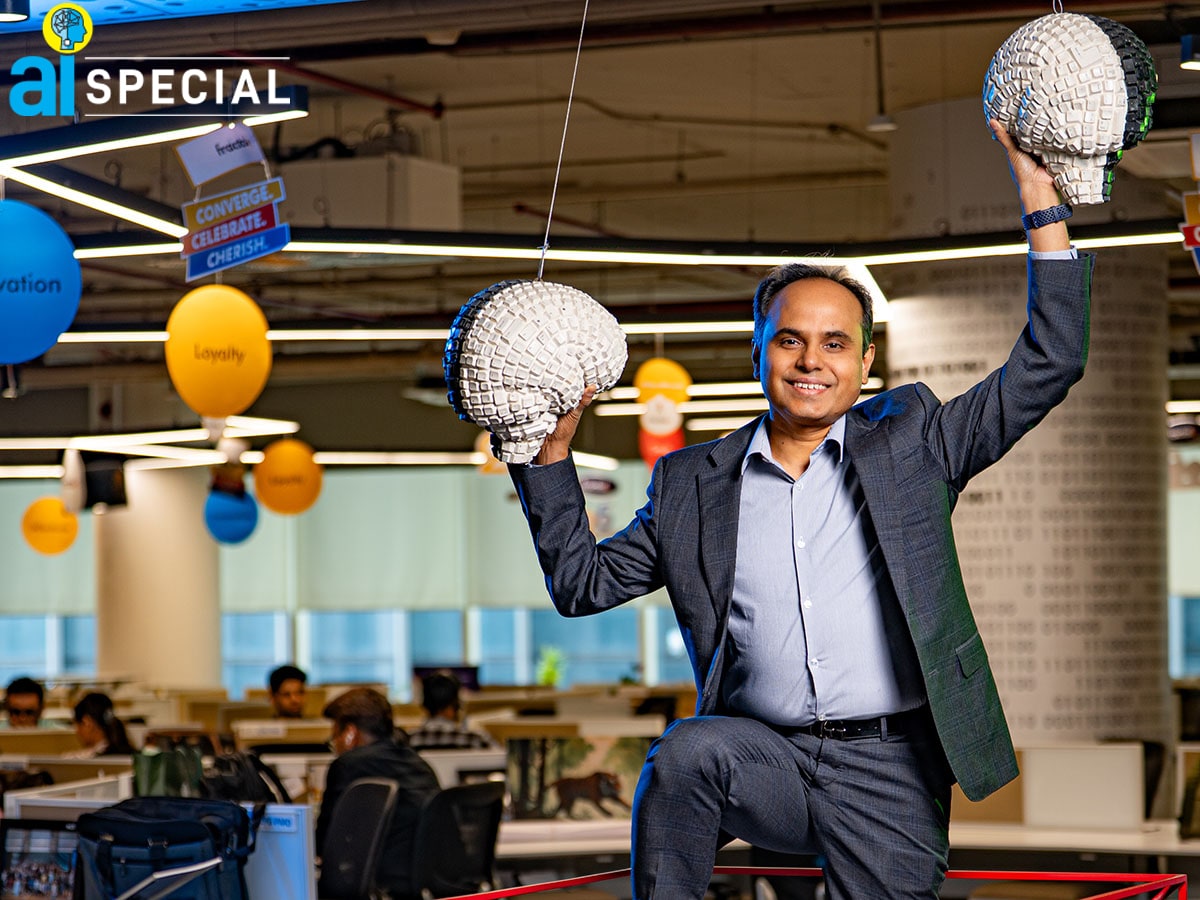Srikanth Velamakanni in the Fractal office, holding two brain-shaped display objects