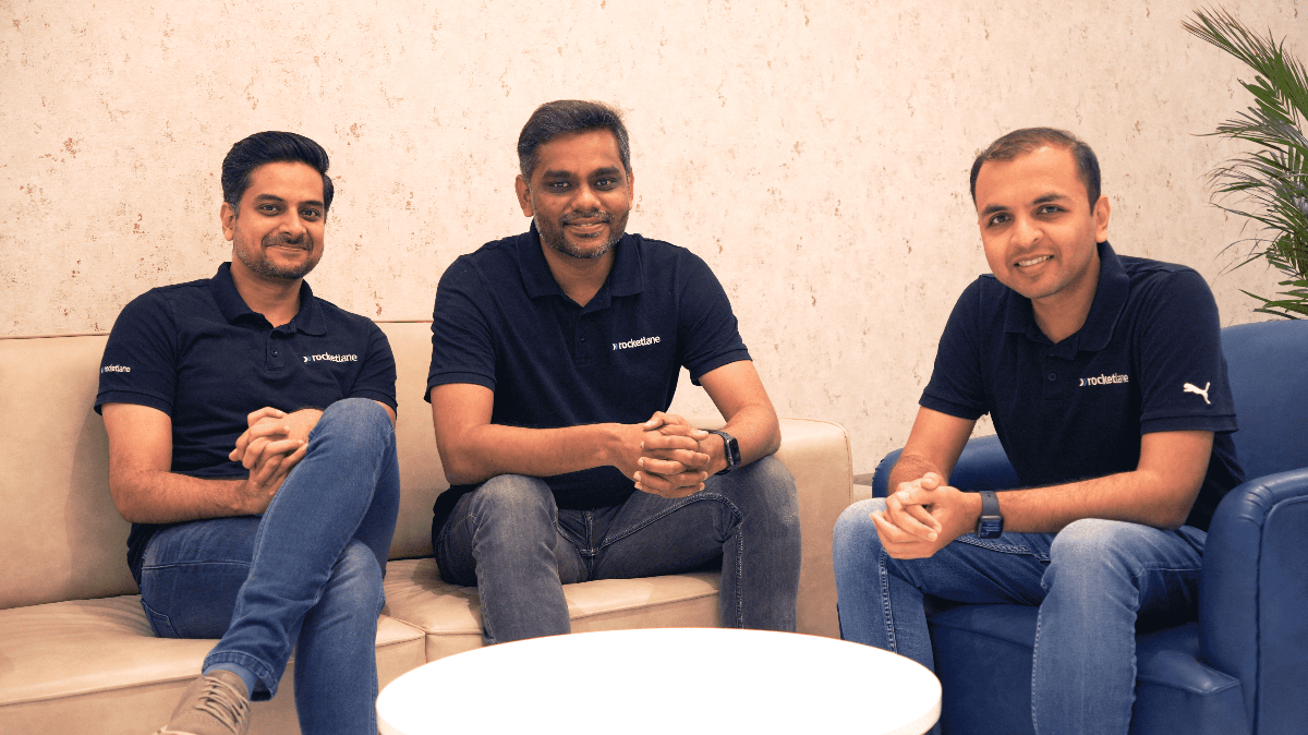 Rocketlane’s three co-founders seated together in navy company polo shirts