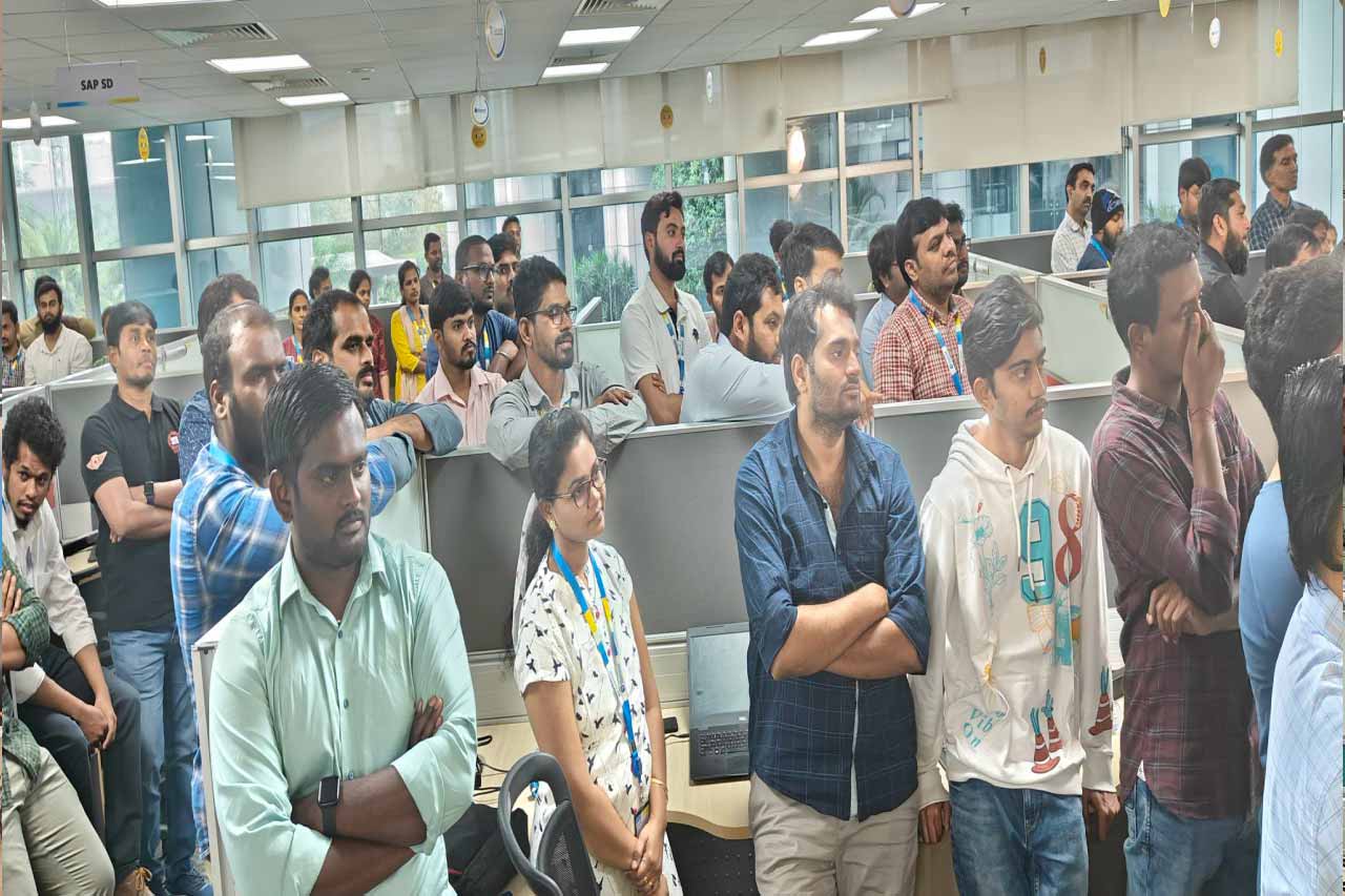 Gemini employees gathered among office cubicles for a leadership session