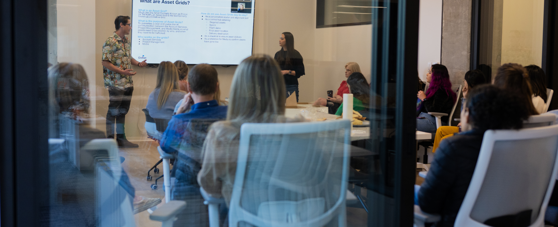 Civilian colleagues gathered around a conference table during a presentation