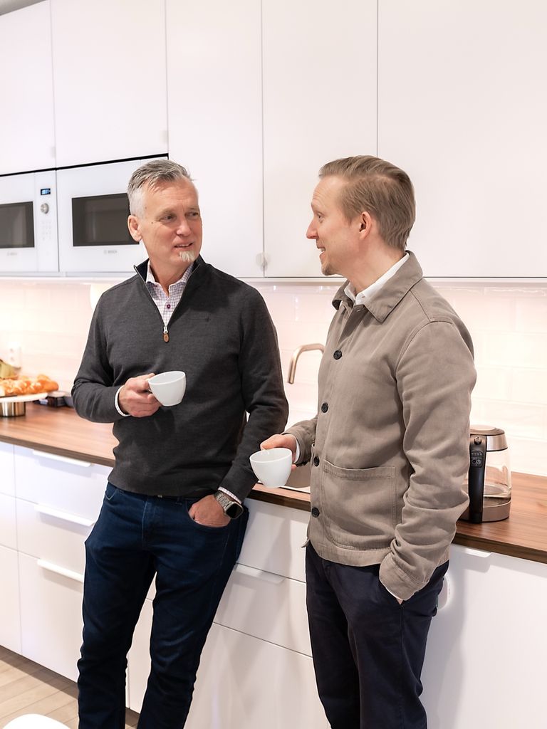 Staffan Hillberg on the left and Millow CEO Fredrik Öhrn talking over coffee in a kitchen