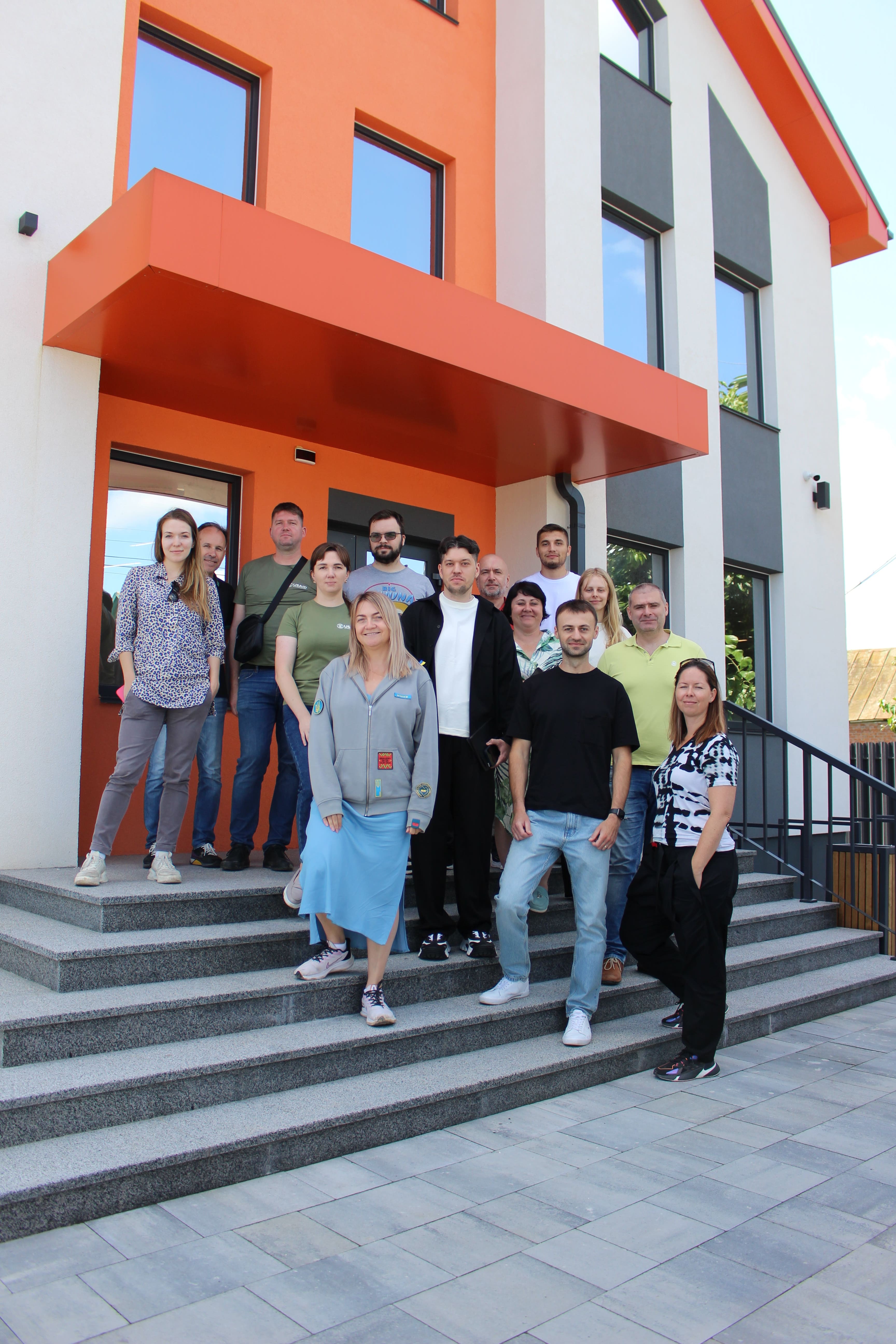 Stakh Vozniak with Cargofy colleagues outside an orange-and-white office building