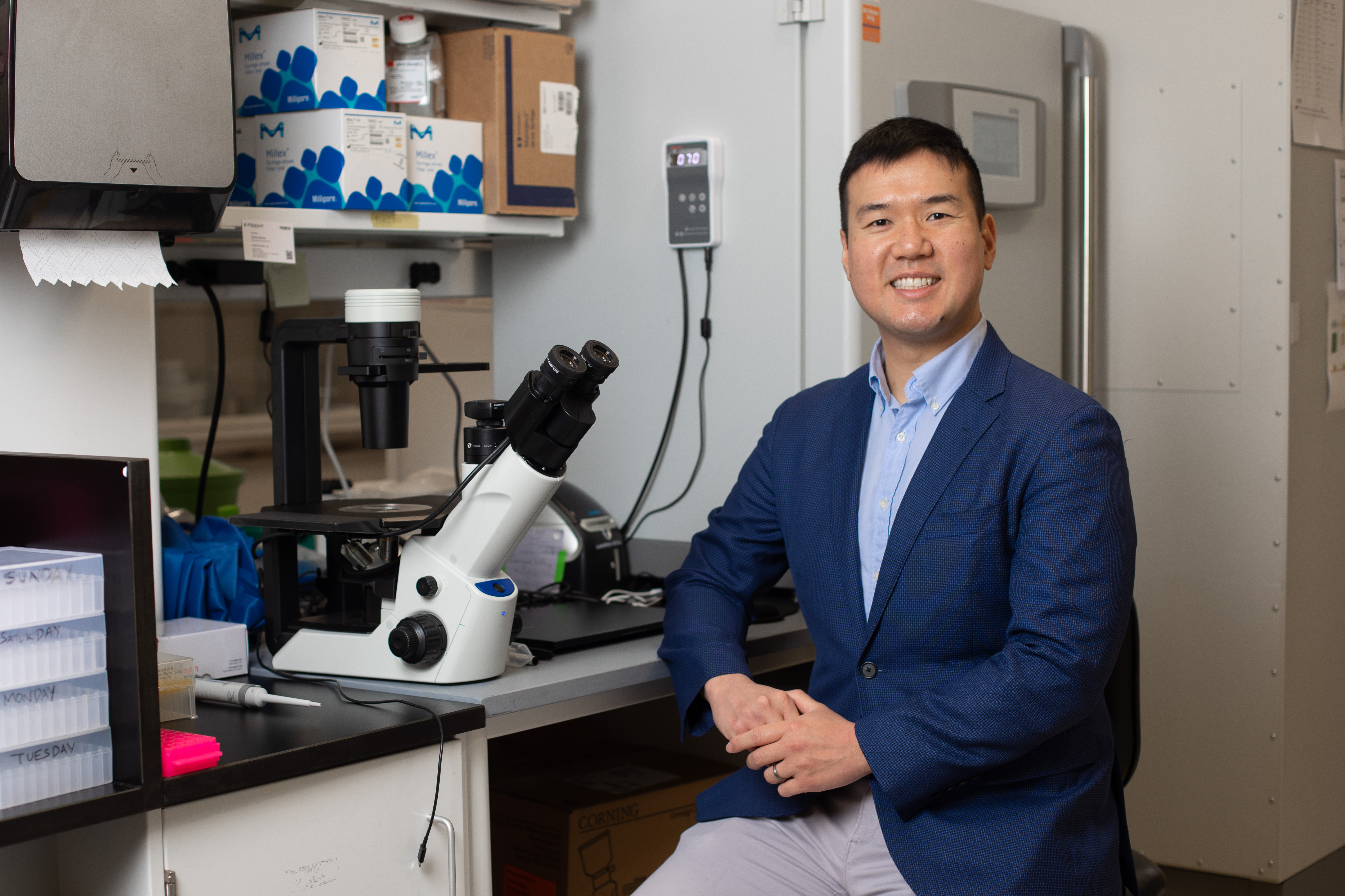 Stan Wang seated at a laboratory bench in Cambridge