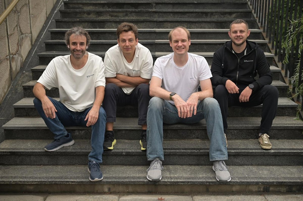 MiLaboratories co-founders seated together on outdoor stone steps, with Stanislav Poslavsky second from left