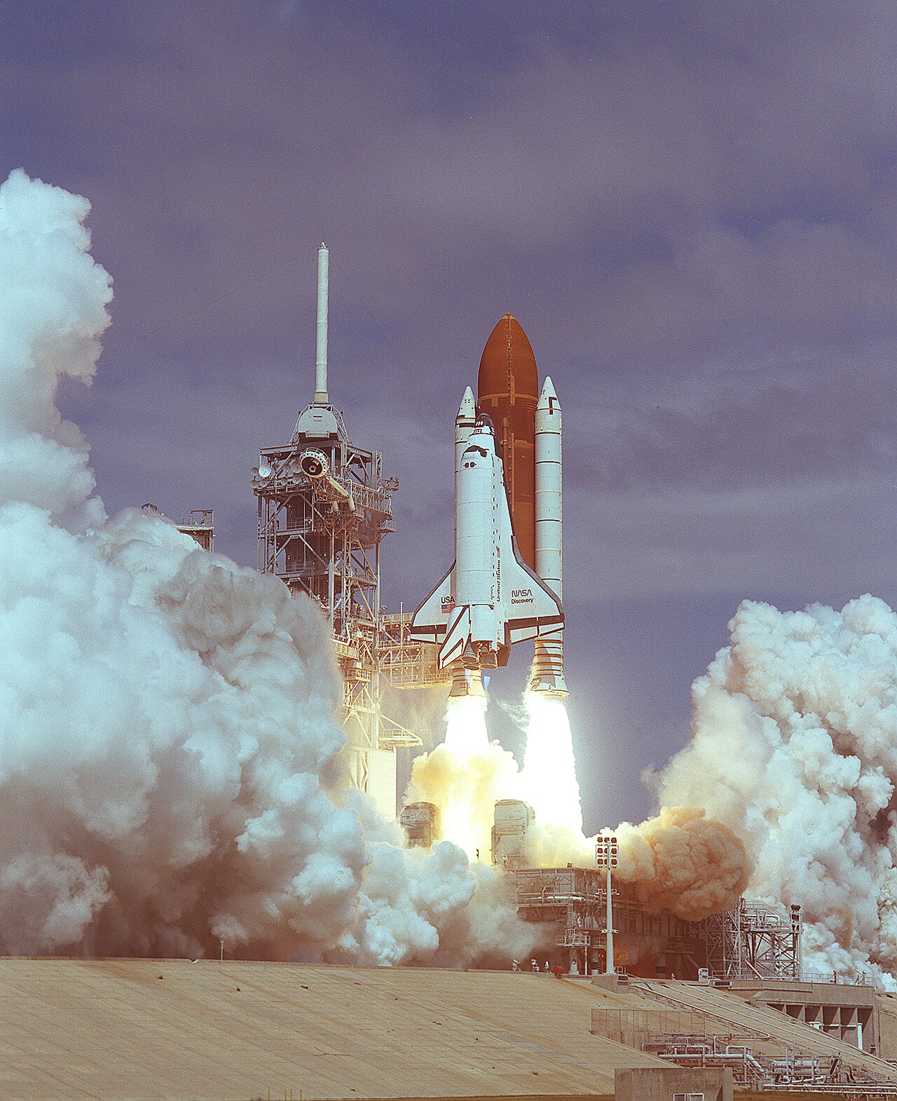 Space shuttle Discovery launching into a purple sky