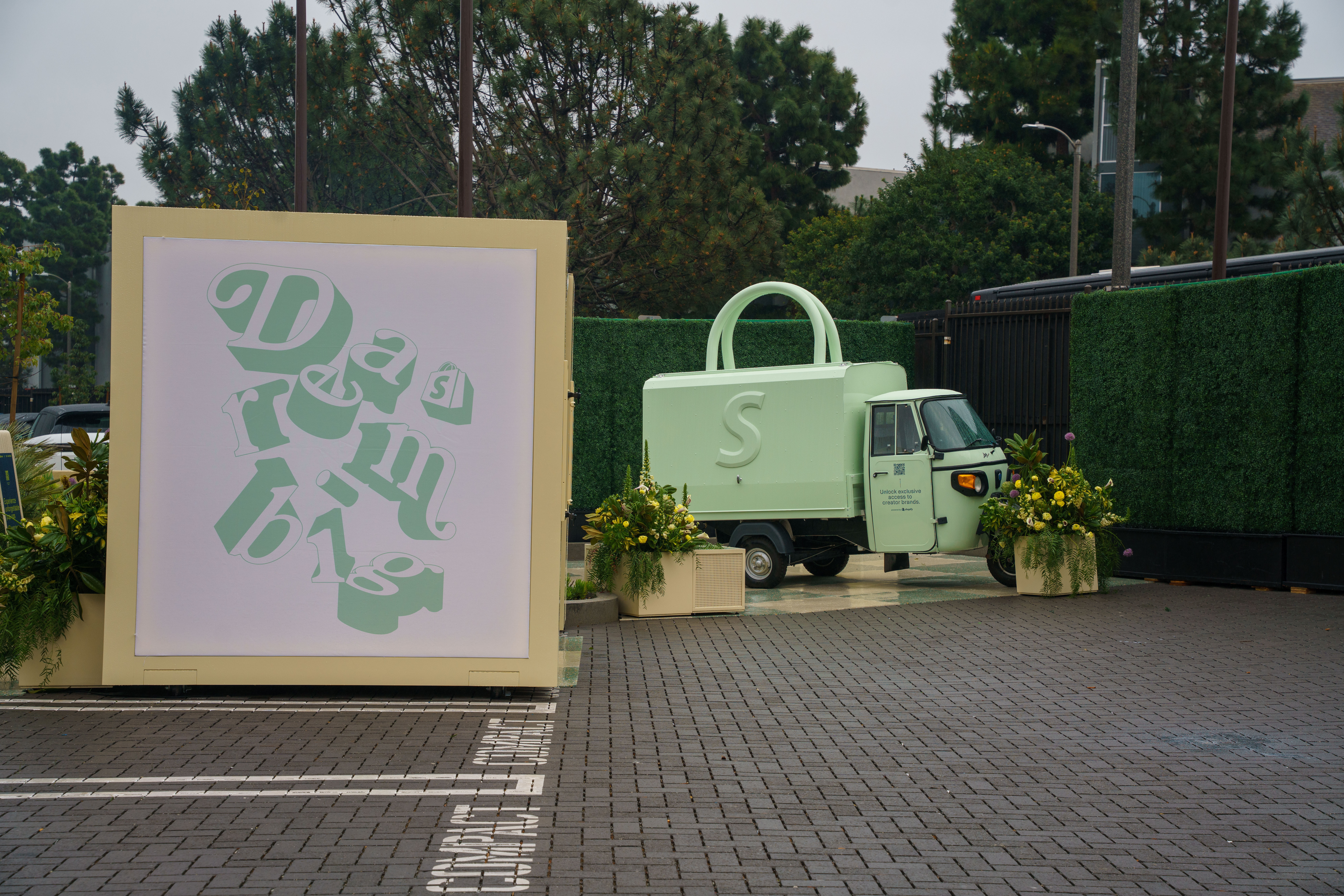 A Piaggio Ape converted into Shopify’s green shopping bag at an outdoor retail activation