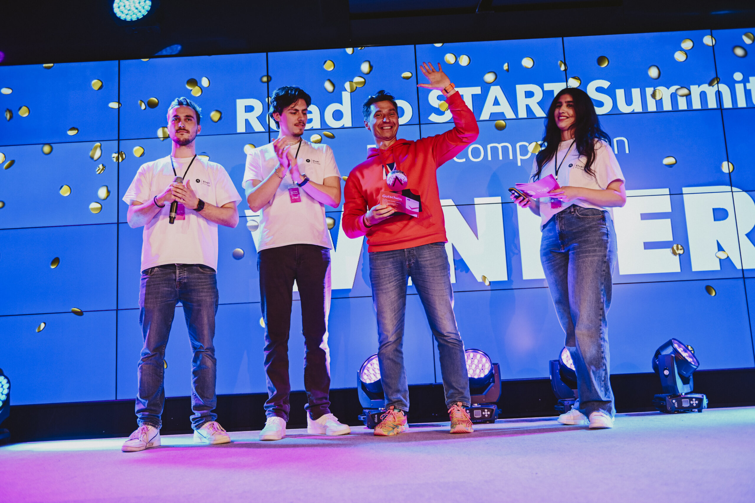 A celebratory moment on the Road to START Summit stage, with organizers and a participant holding an award