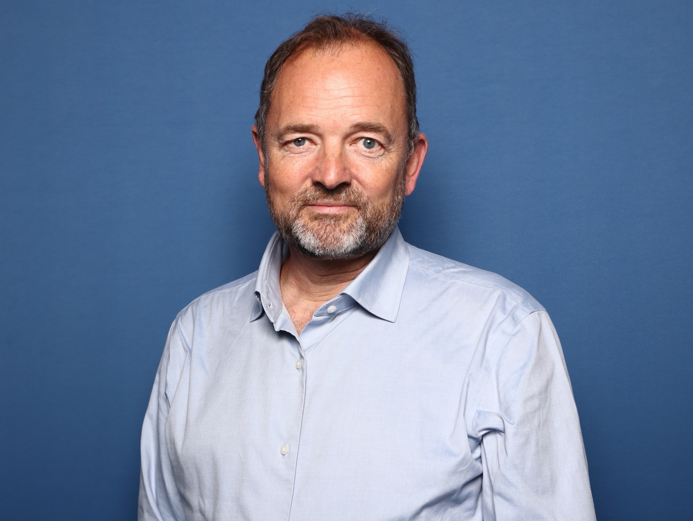 GrowthWheel founder David Madié in a light blue shirt against a blue background