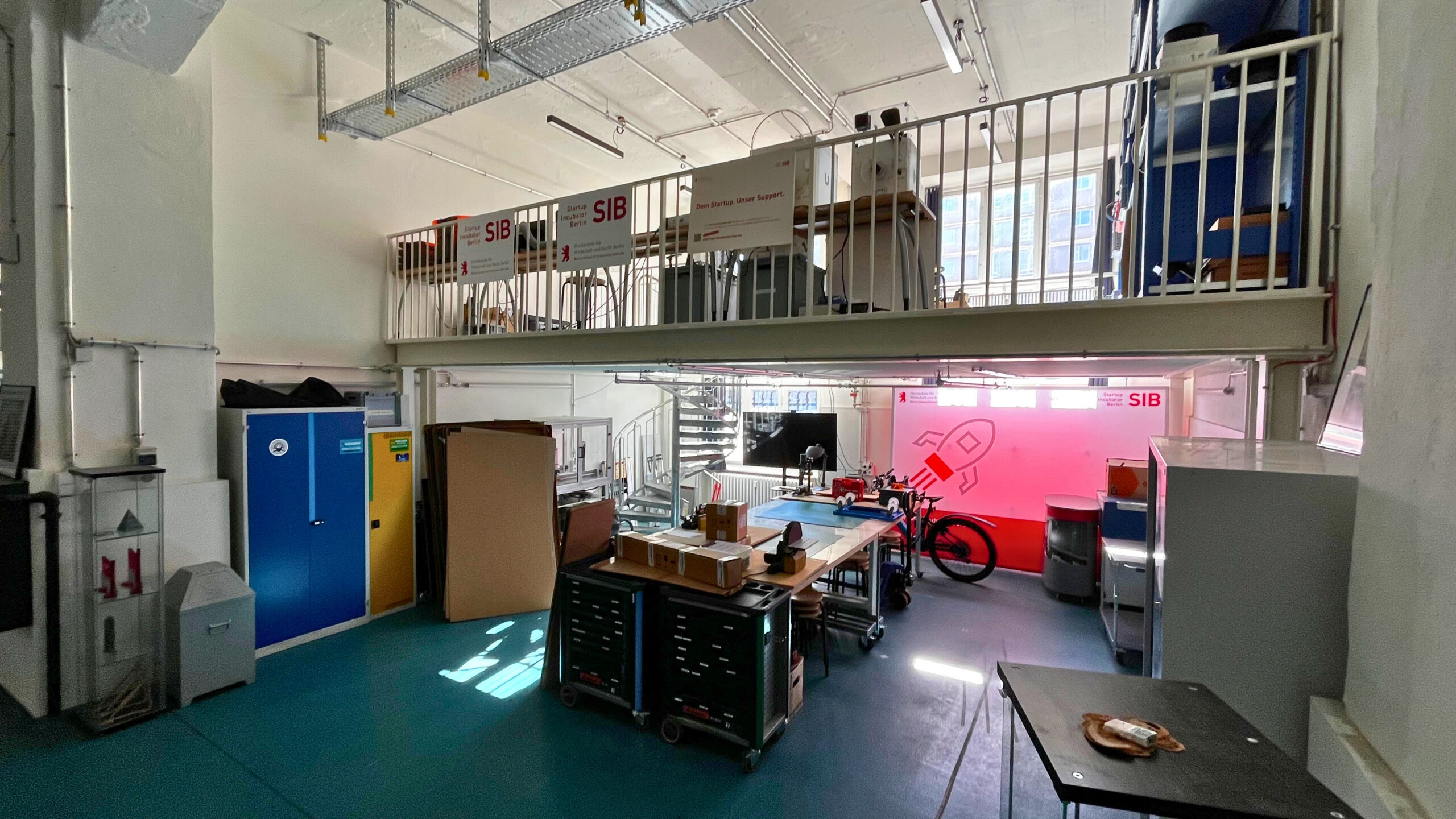 Archive view of SIB’s prototype workshop, with workbenches, tools and a mezzanine