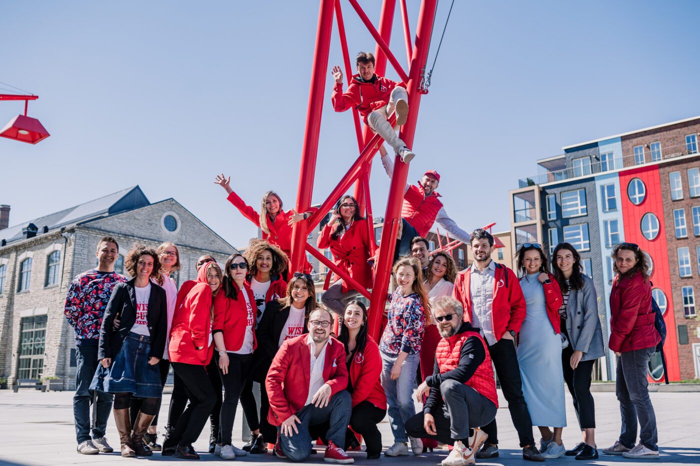 Startup Wise Guys team posing outdoors around a red metal structure