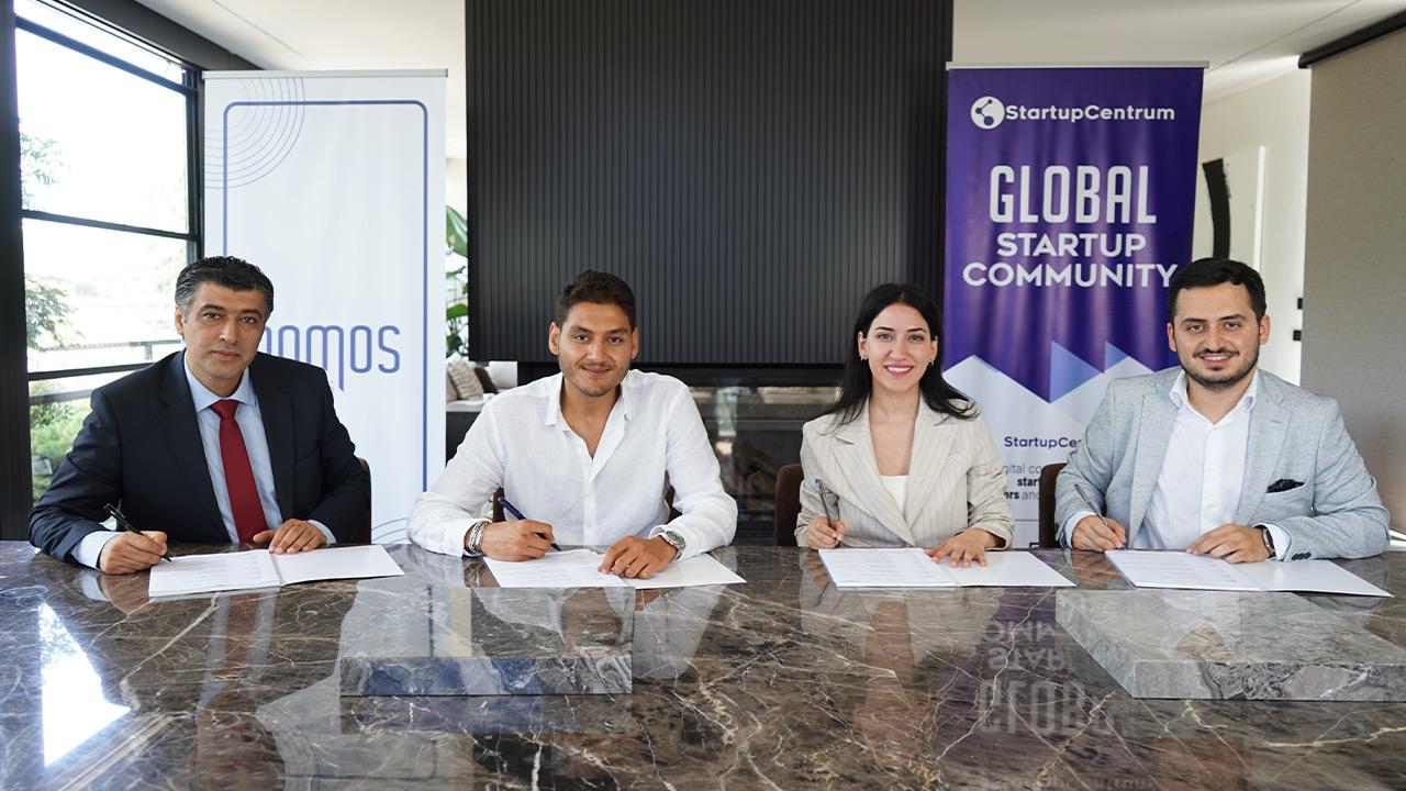Four participants seated at the signing table in StartupCentrum’s August 2024 funding announcement photograph
