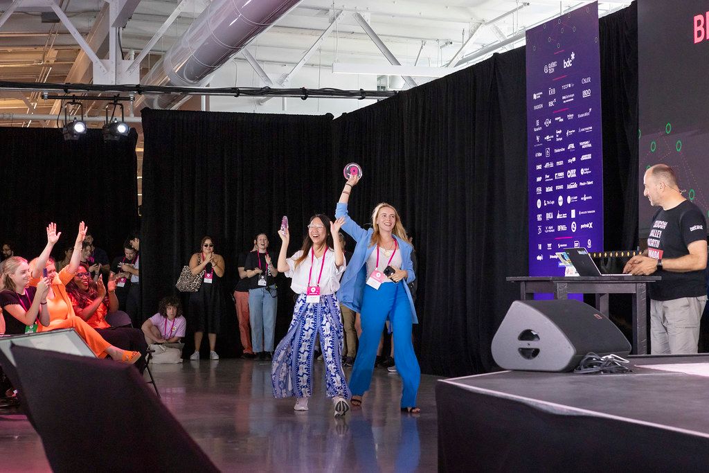 Attendees celebrating beside a Startupfest stage