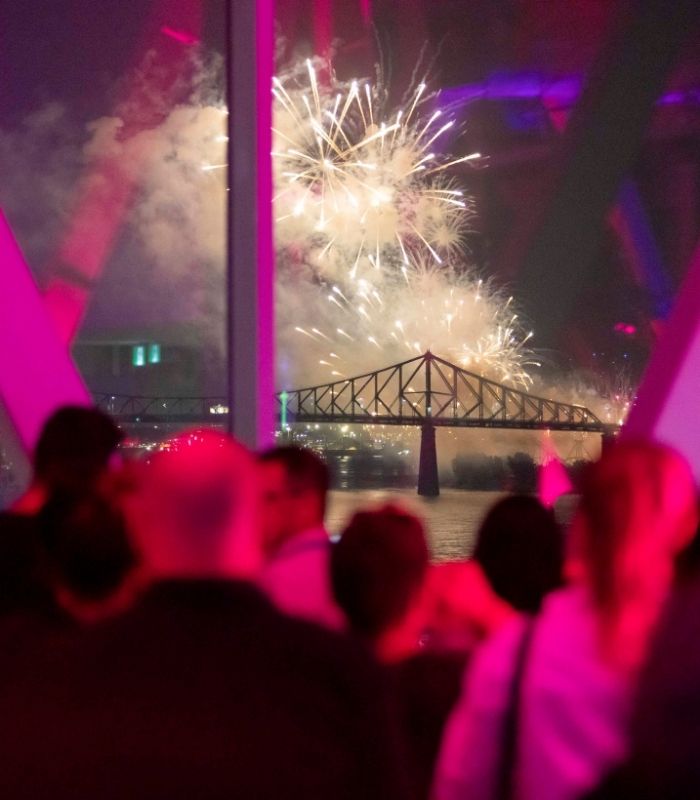 Guests watching fireworks through waterfront windows
