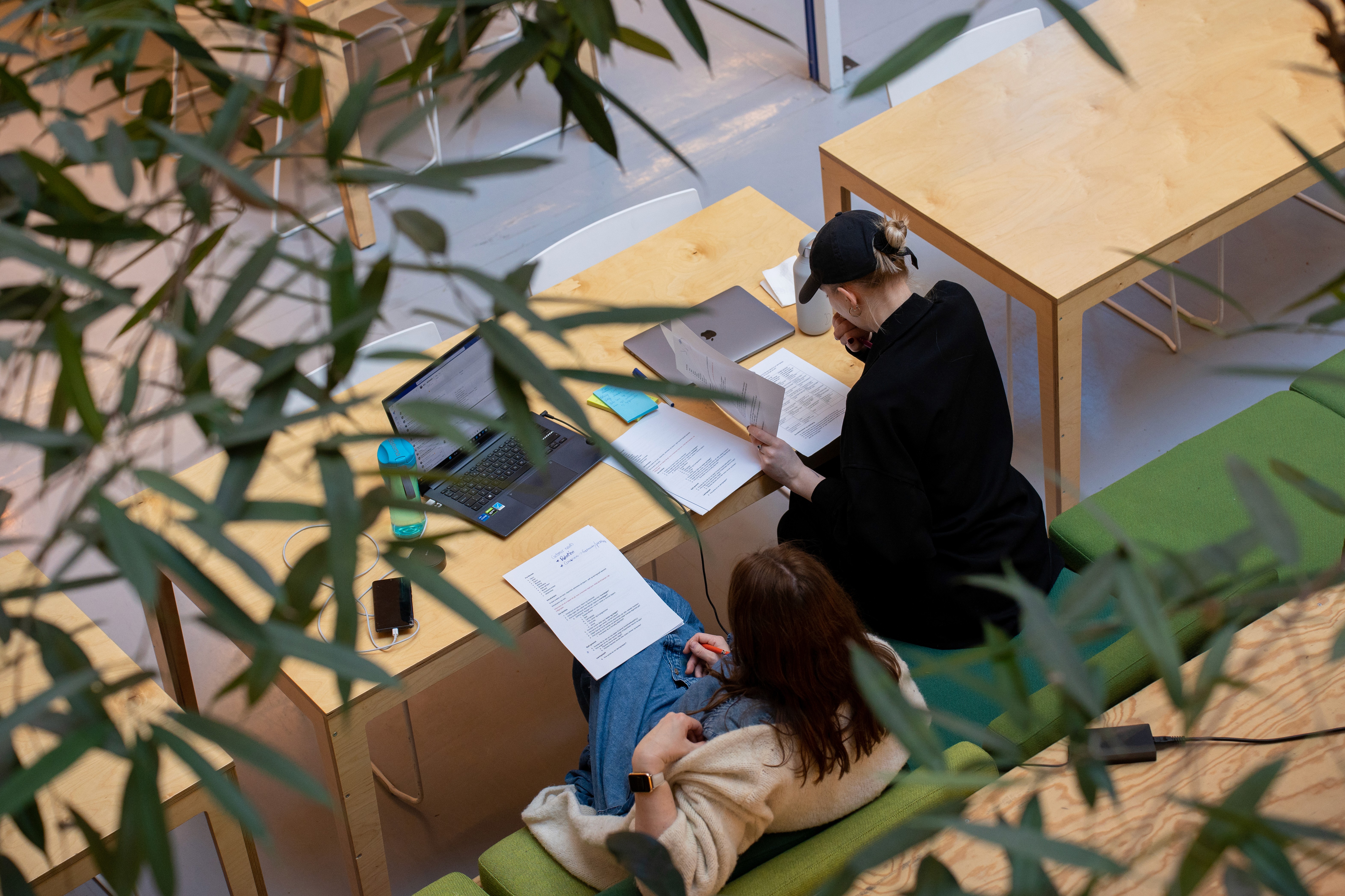Two people reviewing documents at a shared workspace table
