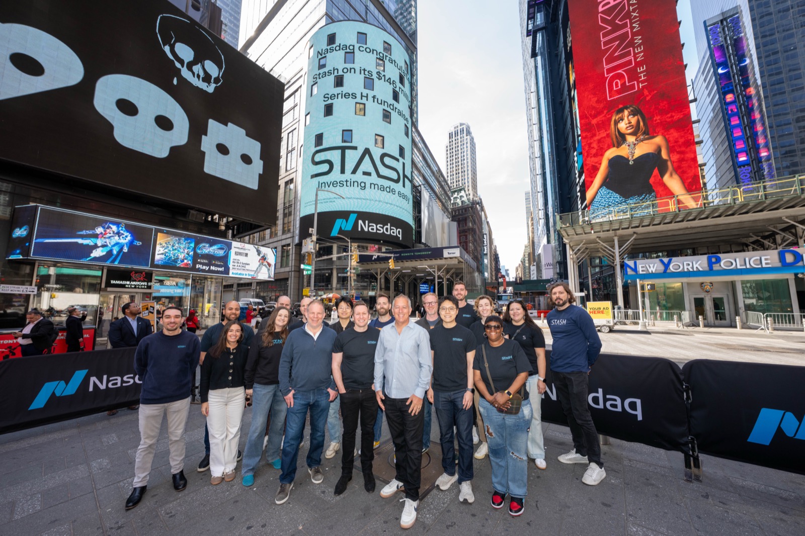 Stash team gathered in Times Square beneath a Nasdaq billboard celebrating its Series H funding