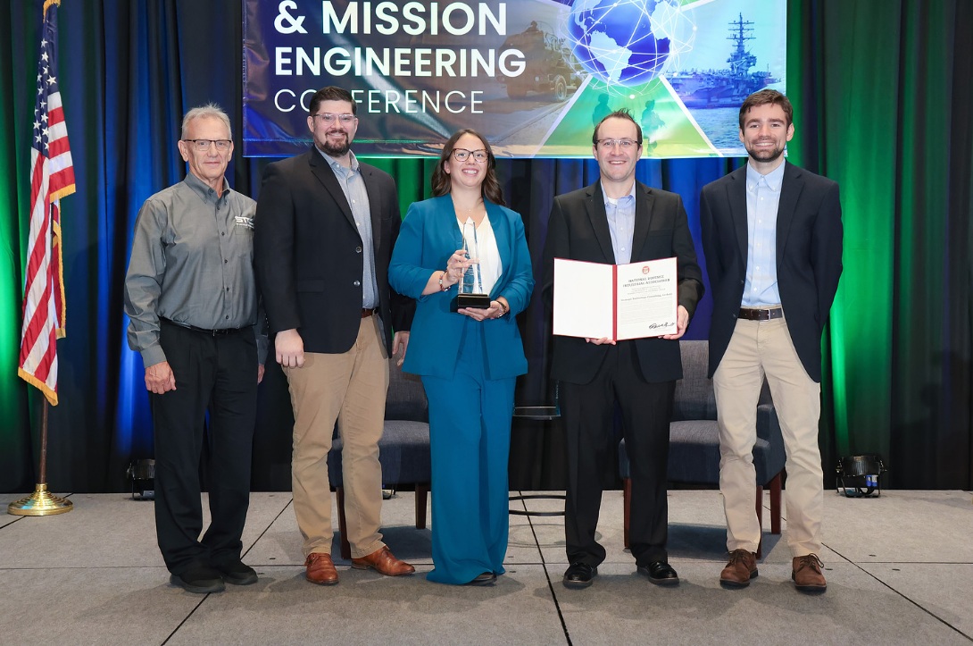 Five people pose with an engineering award and certificate at the Systems and Mission Engineering Conference.