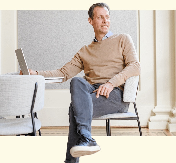Stefan Debois seated beside a laptop in a light-filled workspace