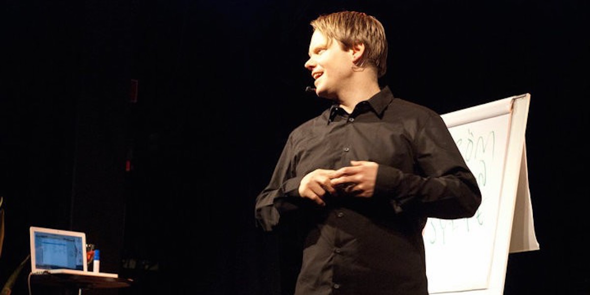 Stefan Skoglund speaking beside a flip chart, wearing a headset microphone