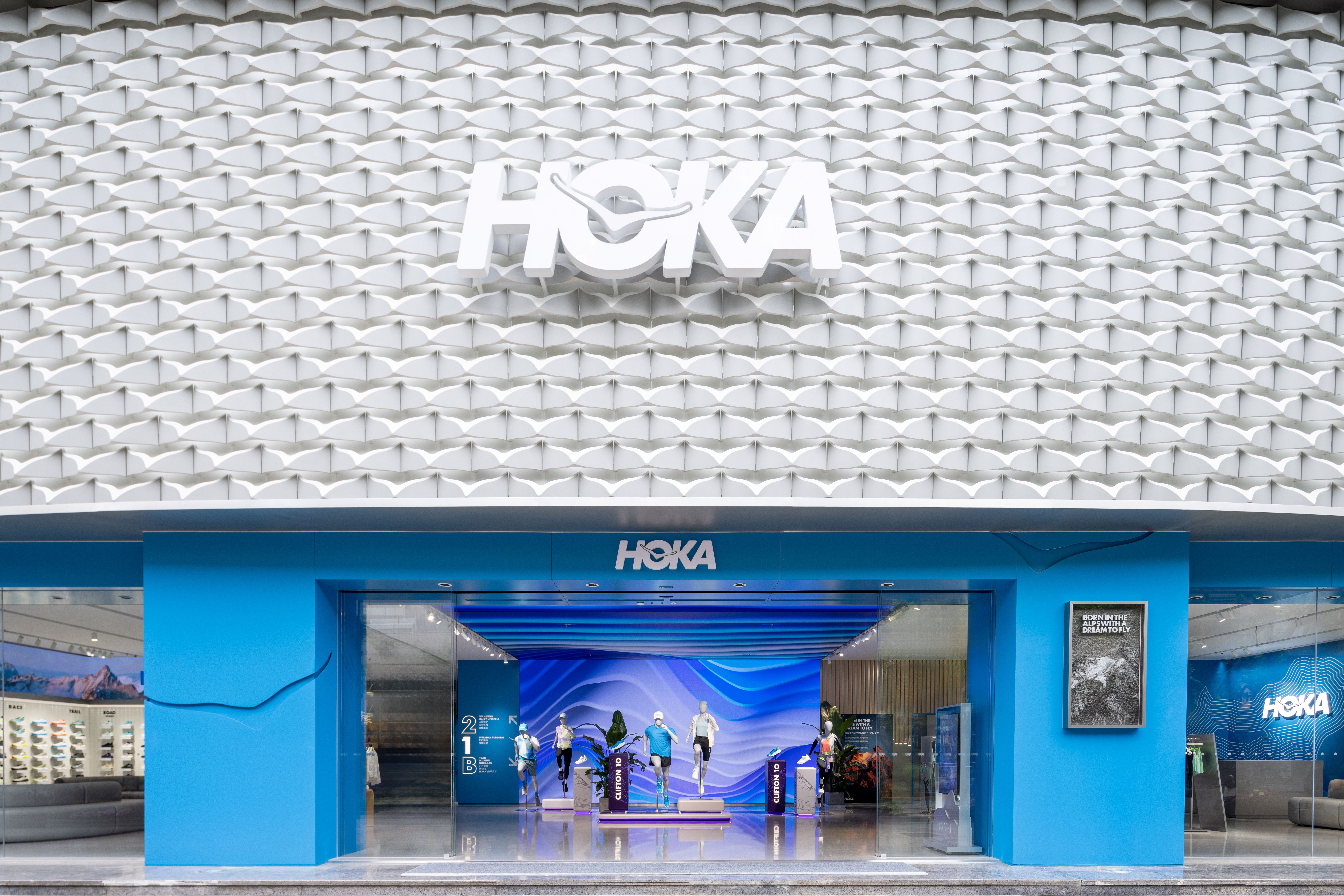 HOKA’s Shanghai brand experience center, with a sculpted white facade and blue entrance
