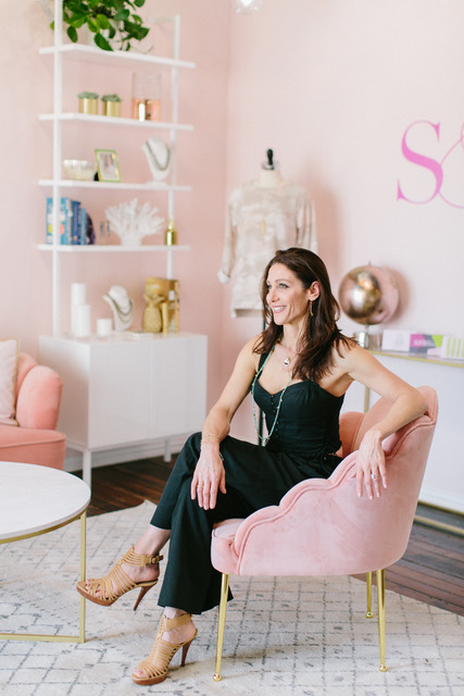 Stella and Dot founder Jessica Herrin seated in a brand showroom