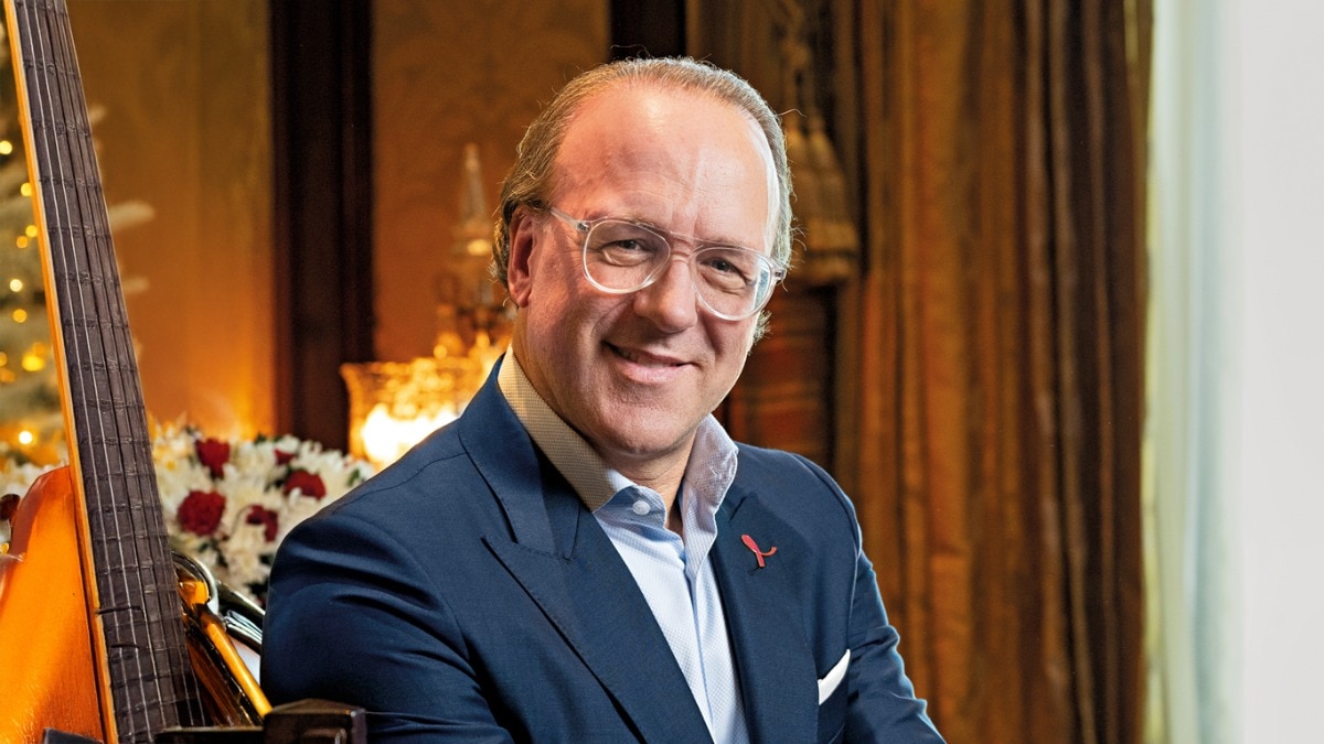 Stéphane de La Faverie seated in a navy jacket and clear-framed glasses