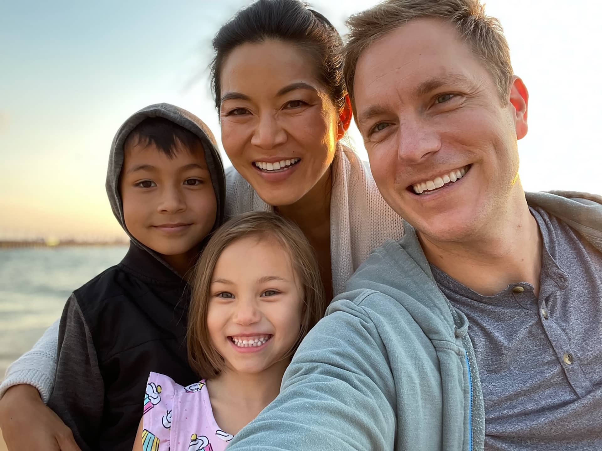 Stephanie Cho with her husband, son, and daughter outdoors near the water