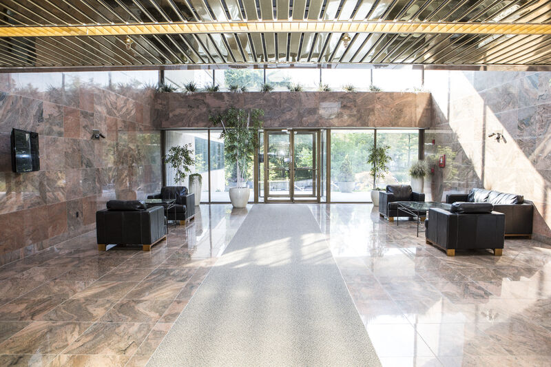 Sunlit Southridge Holdings lobby with polished stone floors, black seating and glass entrance doors