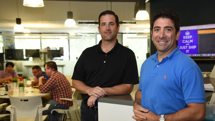 Stephen Pair and Tony Gallippi standing in BitPay's open-plan office