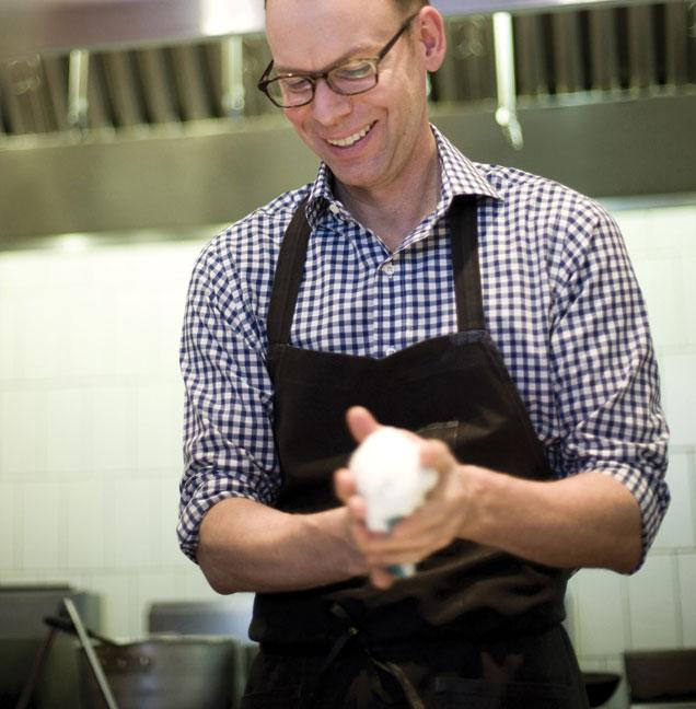 Steve Ells wearing an apron and working with his hands in a restaurant kitchen