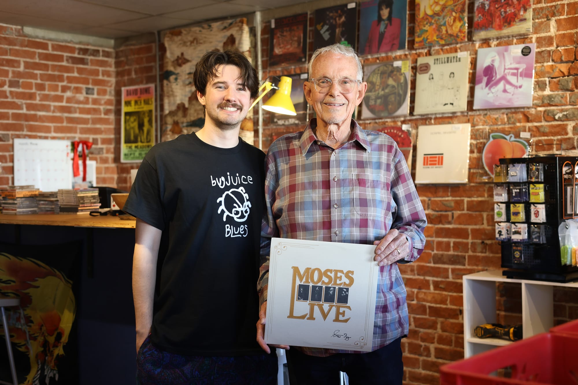 Henry Ramsay and Steve Irby holding a signed Moses Live album at Velvet Fudge