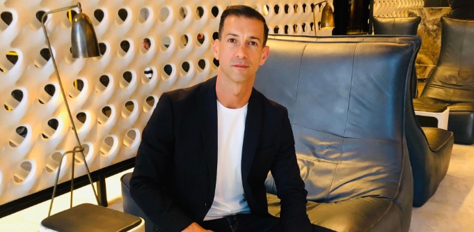 Steve Maarbani seated in a lounge chair, wearing a dark jacket and white shirt
