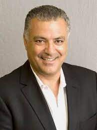 Steve Nasiri in a dark jacket and open-collar white shirt