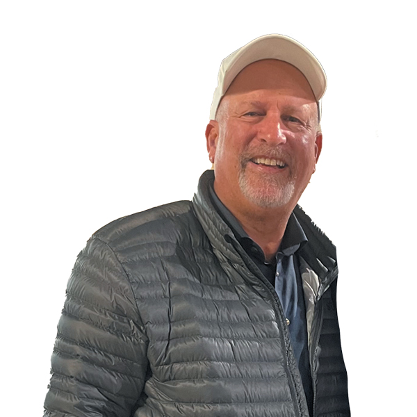 Steve Hilton smiling in a cap and casual jacket