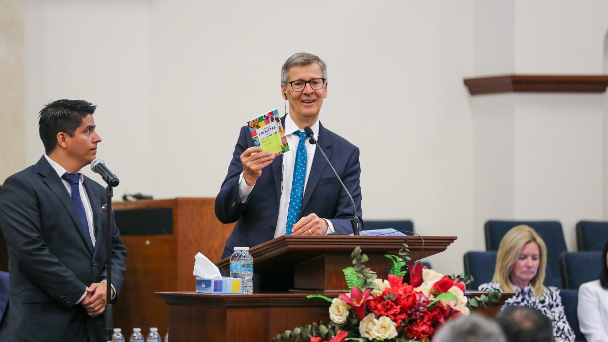 Steven J. Lund holding the For the Strength of Youth guide while speaking in Monterrey, Mexico
