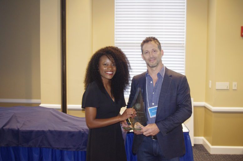 Steven Schnall, right, and Marsha Joseph hold an award together
